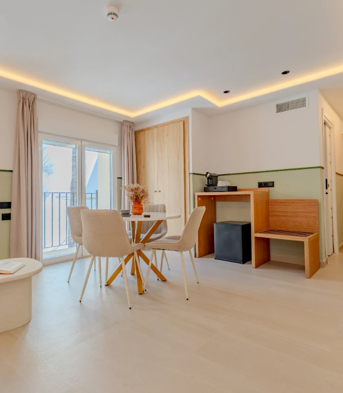 Sala moderna con mesa, sillas, barra de madera y ventana al balc&oacute;n.